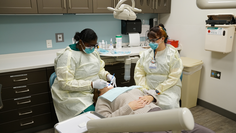 Dental resident and faculty at work together
