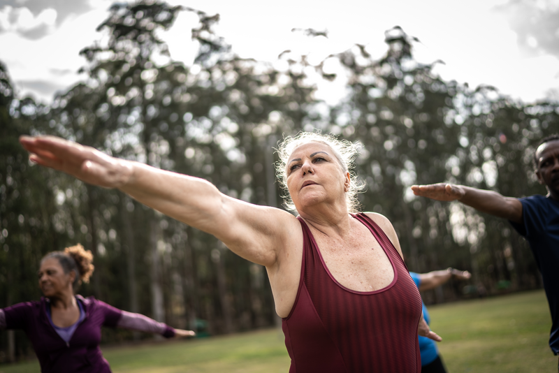 Senior woman exercising in a park with friends - stock photo
Senior woman exercising in a park with friends