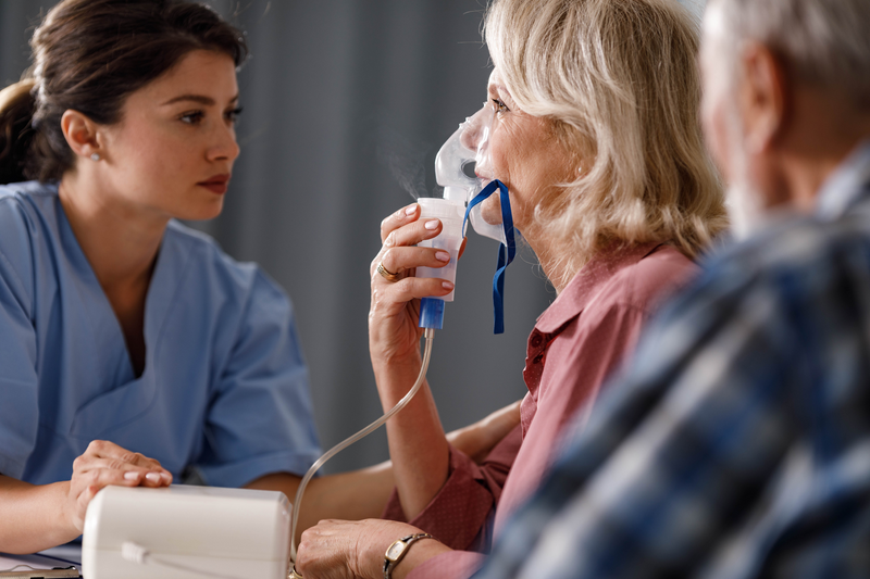 Inhaling through nebulizer at doctor's office! - stock photo
Senior woman using breath vapor while having a medical exam at doctor's office.