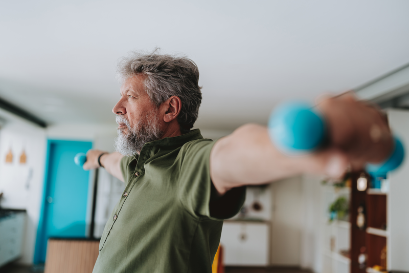 Elderly man exercising at home with dumbbell physiotherapy - stock photo
Elderly man exercising at home with dumbbell physiotherapy